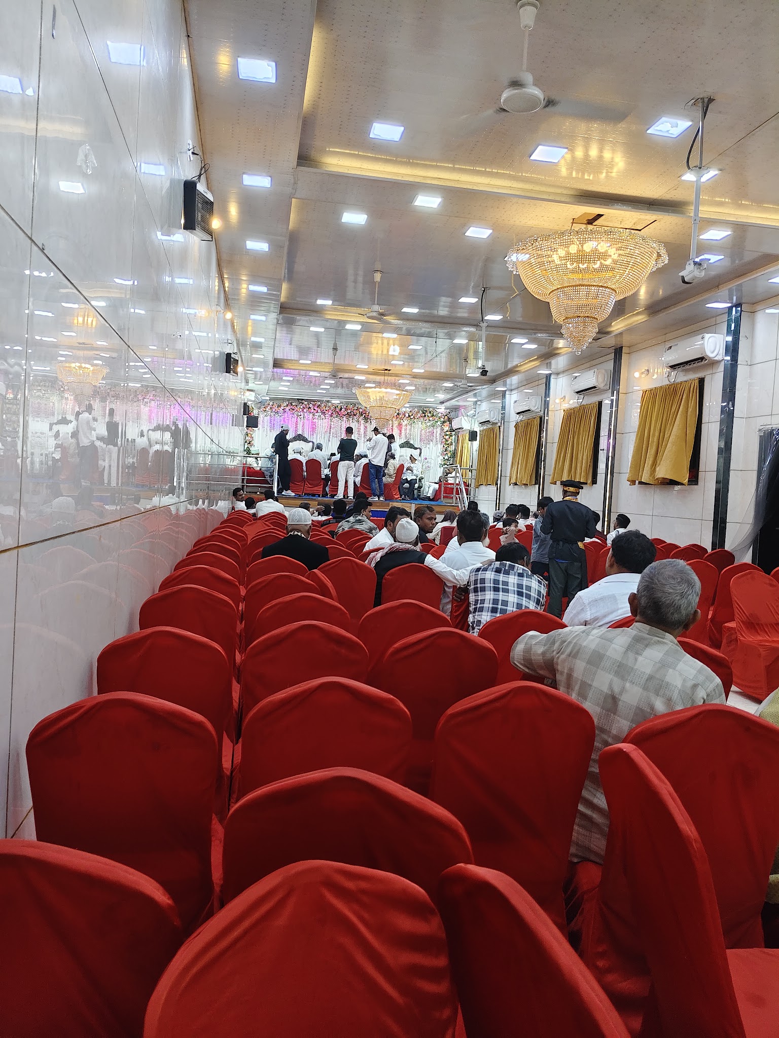 Red covered seating and chandelier in the banquet hall.